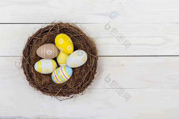 复活节背景，鸡蛋在白木上筑巢。 顶部视图与复制空间
