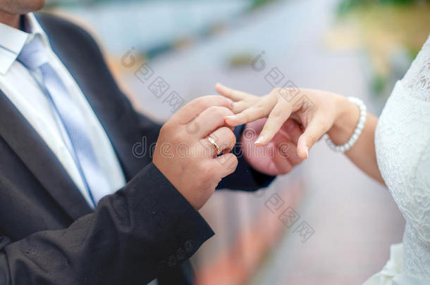 新郎在新娘的手指上戴着<strong>结婚</strong>戒指。 一对槟榔