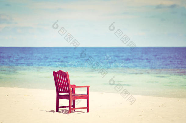 沙滩椅在白沙滩阳光明媚的天空背景下，复古的色调-暑假的概念