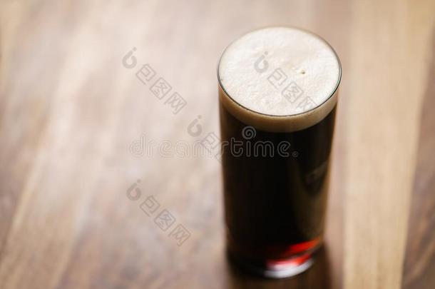 黑暗的啤酒涌出采用玻璃向木材表