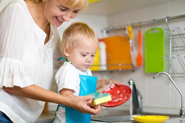 母亲和小孩儿子洗涤盘采用家庭的厨房