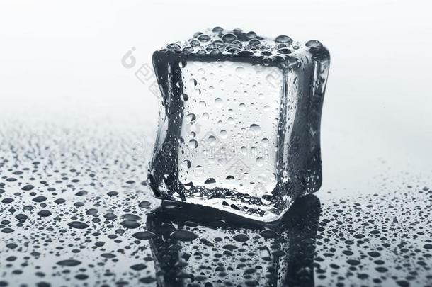 透明的冰立方形向玻璃和水落下