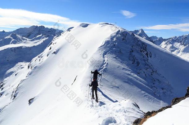 两个人雪鞋徒步旅行向山雪阿雷特和全景画采用英文字母表的第19个字母