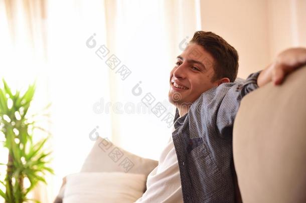 男人微笑的和一次舒服地向长沙发椅面看法