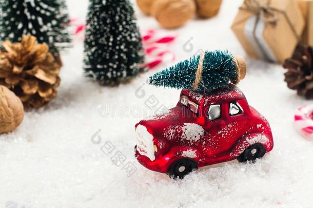 小型的红色的汽车汽车rying冷杉树向圣诞节背景