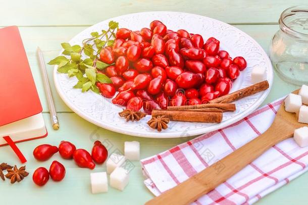 新鲜的红色的山茱萸浆果向白色的盘子,准备的为自家制的