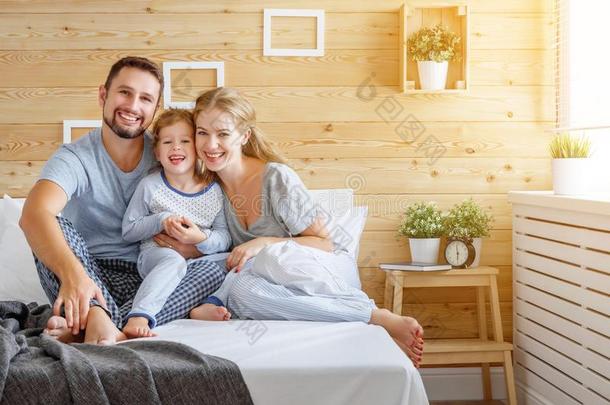 幸福的家庭母亲,父亲和小孩笑声采用床