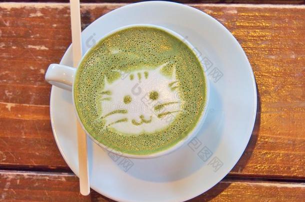 日本抹茶绿色的茶水拿铁咖啡和拿铁咖啡艺术`猫面容`