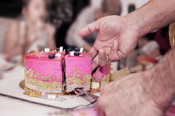生日蛋糕粉红色的高的发光的被修饰的和发光的小珠子将切开进入中