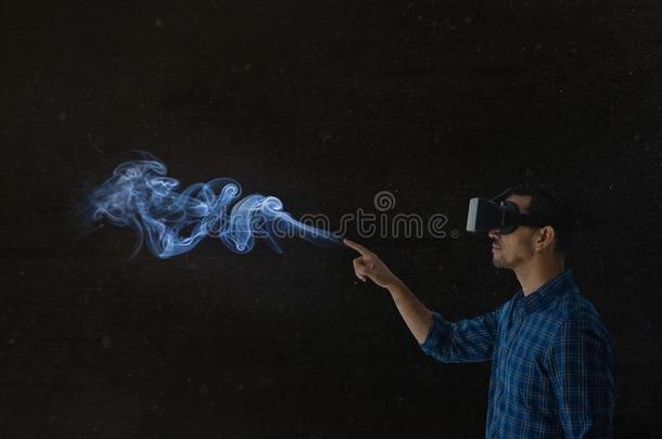 男人使用VirtualReality虚拟现实戴在头上的耳机或听筒采用黑暗的位