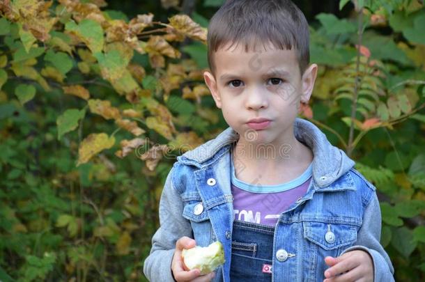 幸福的小孩吃成果.幸福的漂亮的小孩男孩吃一苹果.我