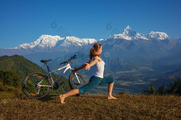 女人开业的瑜伽,令人轻松的后的骑马自行车高的采用登上