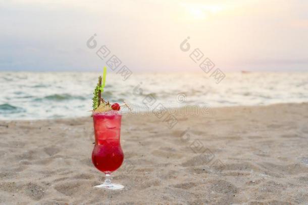 红色的鸡尾酒喝向沙采用海滩采用黎明海&天后面