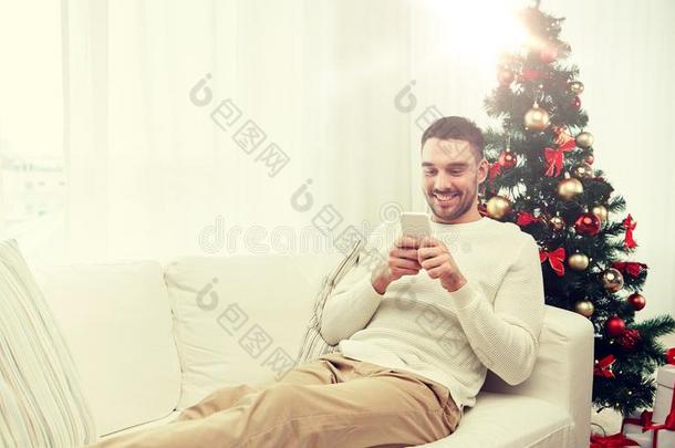 微笑的男人和智能<strong>手机</strong>在家为圣诞<strong>节</strong>
