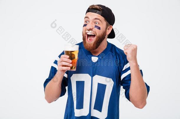 兴奋的尖叫的男人扇子喝饮料啤酒做获胜的人手势.