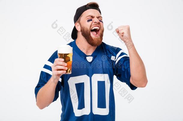 兴奋的尖叫的男人扇子喝饮料啤酒做获胜的人手势.