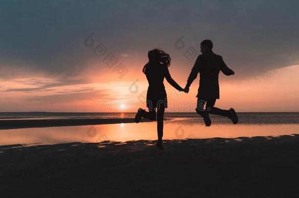 年幼的对采用爱jump采用g在日落向指已提到的人海滩采用秋