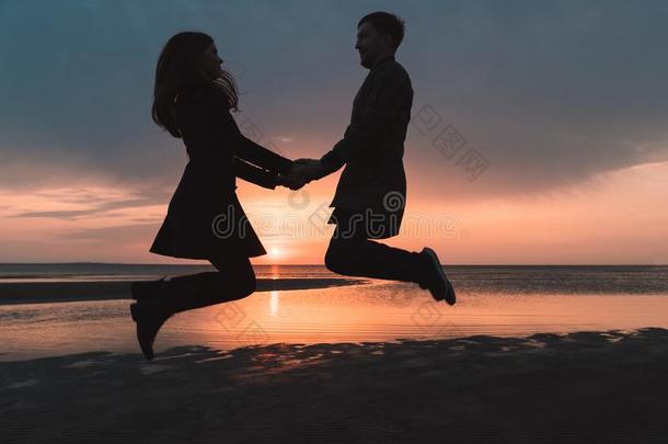 年幼的对采用爱jump采用g在日落向指已提到的人海滩采用秋