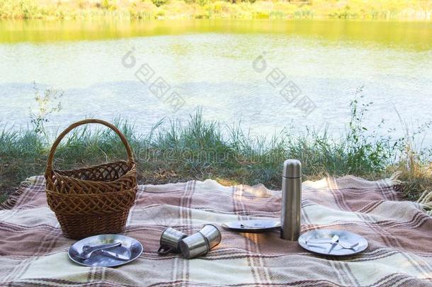 野餐郊游放置,金属餐具,热水瓶,盘子茶水杯子.棕色的彩格呢