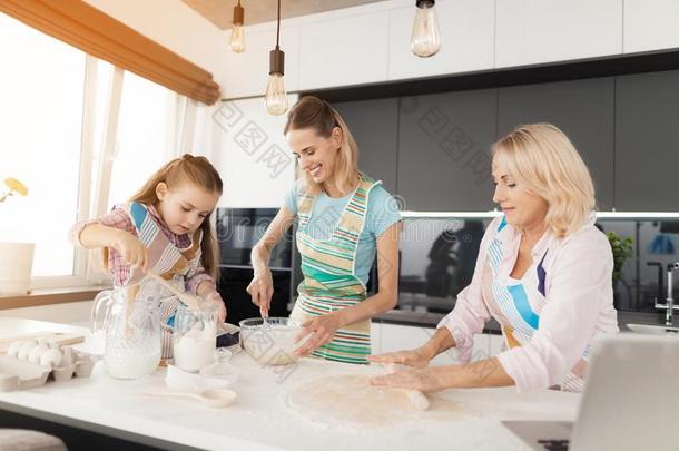 一女人和她mot她是<strong>教学</strong>他们的女儿向烹调蛋糕
