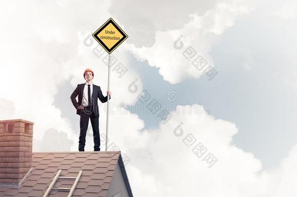 年幼的商人向房屋砖屋顶佃户租种的土地黄色的广告牌.