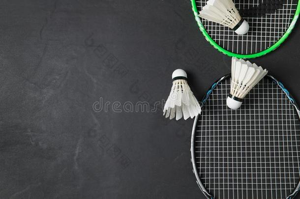 羽毛球和羽毛球球拍向黑的背景.