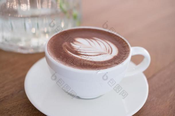 热的巧克力喝和叶子拿铁咖啡艺术.可可饮料向木材
