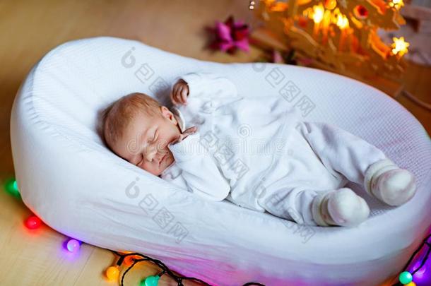 num.一一星期老的新生的婴儿女孩睡眠在近处圣诞节树