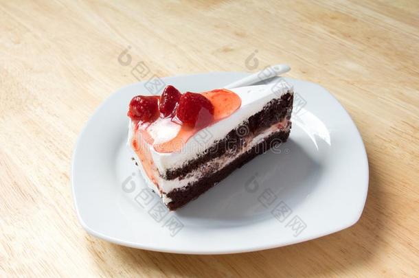 草莓蛋糕和白色的盘子向木制的背景