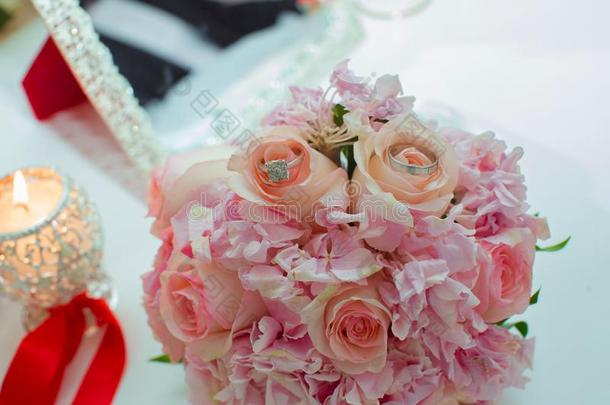 婚礼花束关于粉红色的玫瑰和婚礼戒指向一木制的t一bl