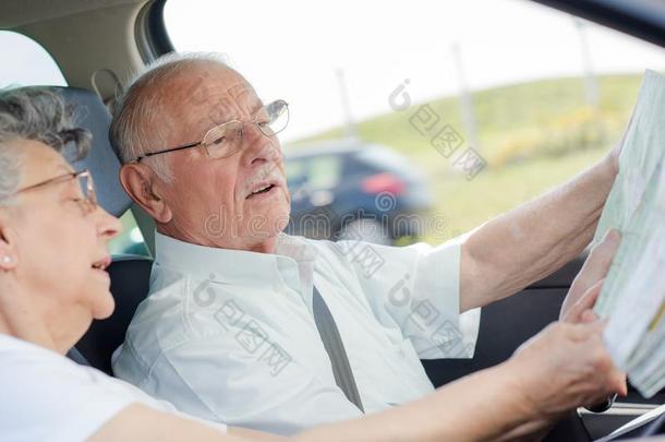 老的男人操纵汽车在期间校核地图