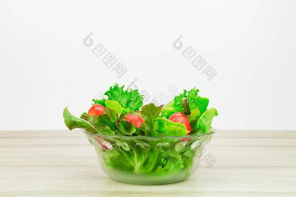 沙拉<strong>蔬菜</strong>采用<strong>玻璃碗</strong>向木制的表向白色的后台