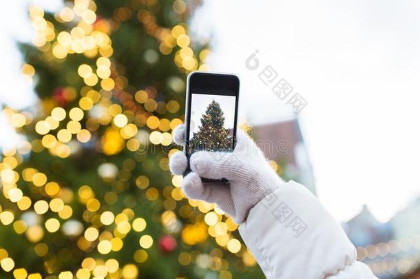 手和智能手机摄影圣诞节树