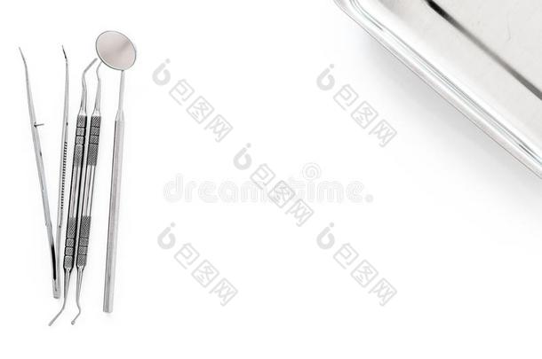 放置关于牙科医生工具在近处小玻璃管向白色的背景顶看法