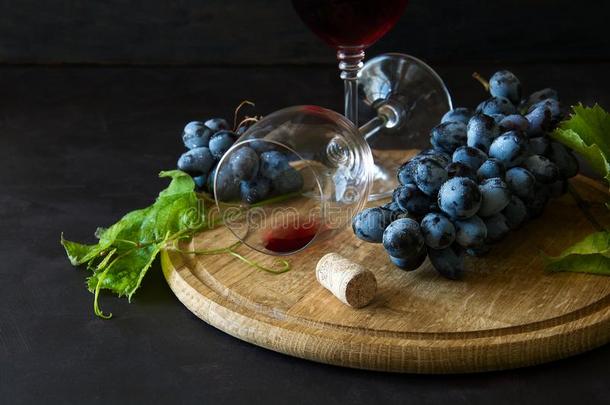 两个酒杯和红色的葡萄酒和葡萄装饰藤树叶