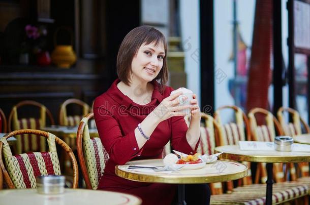 女人喝饮料咖啡豆采用巴黎人户外的咖啡馆