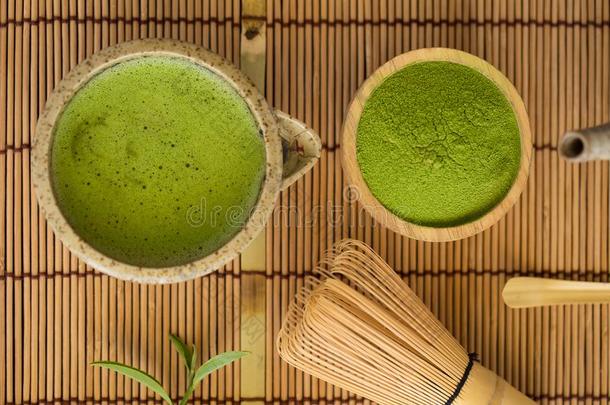 放置关于日本抹茶粉碗木制的勺和拂绿色的茶水叶子