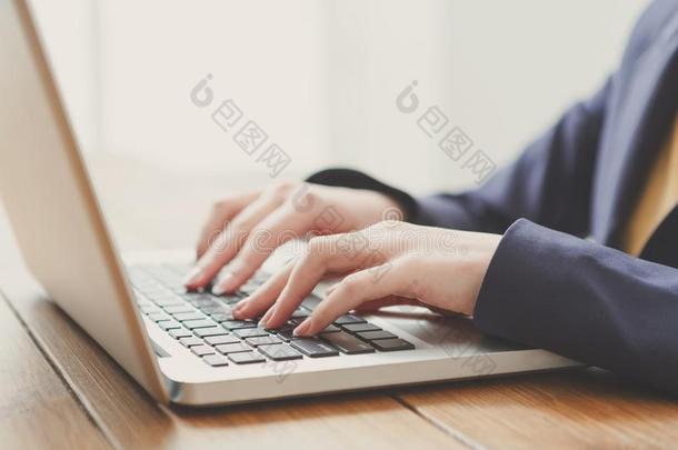 商业女人使用便携式电脑在工作场所,关-在上面