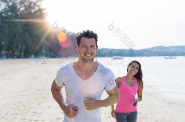 对跑步男人和女人运动跑步的人慢跑向海滩使工作