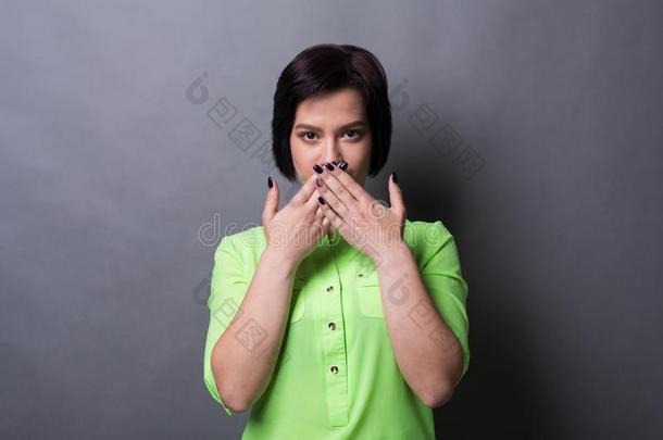 恐惧的女人掩蔽物口和手