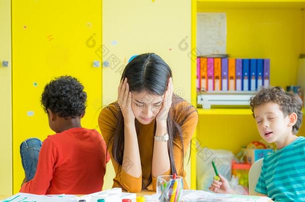 教师得到头痛和两个顽皮的小孩采用教室在k采用de