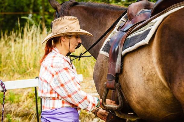 女牛仔获得马准备好的为乘向乡村