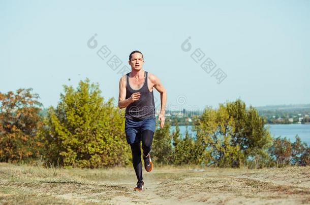 跑步运动.男人赛跑者短距离疾跑户外的采用风景优美的自然.Finland芬兰