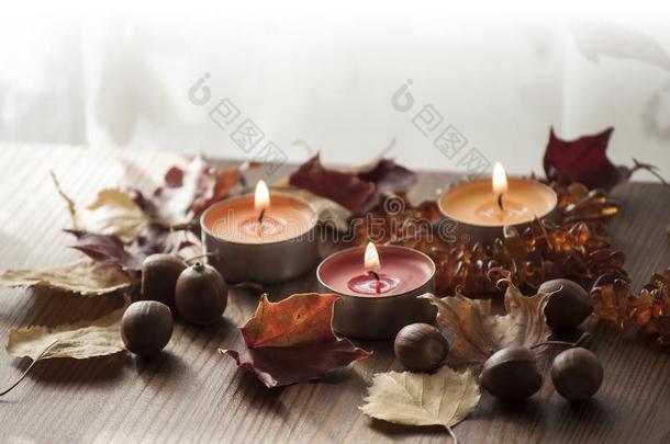 特写镜头关于燃烧的富有色彩的蜡烛和干的干燥的秋树叶和饭前