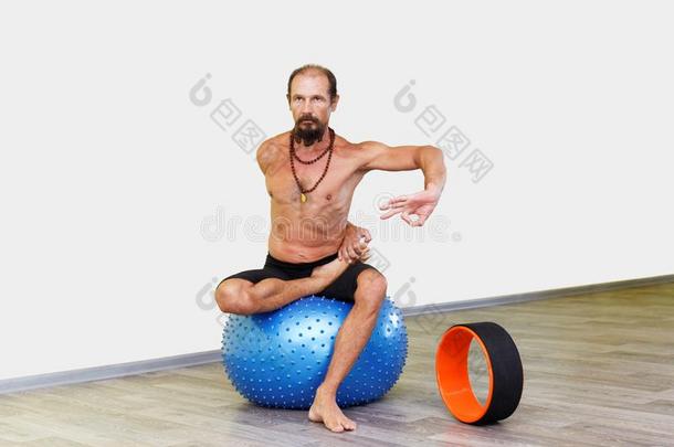 瑜珈修行者男人开业的瑜伽和健康球.
