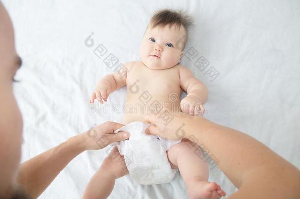爸爸替换尿布向婴儿女孩向床,替换尿布,每一个人