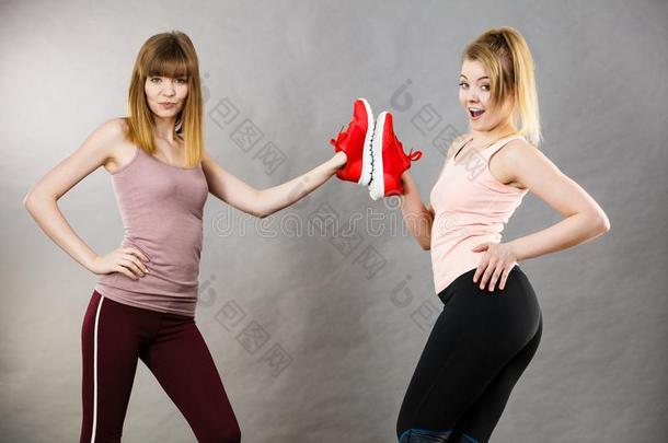 两个女人举向运动装教练鞋子