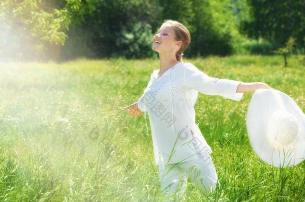 幸福的年幼的女人享有夏向指已提到的人绿色的草地.