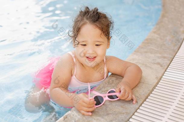 哈萨克人小的女孩演奏在近处游泳水池