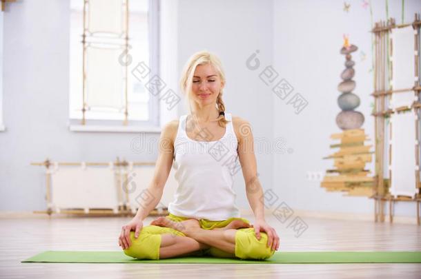 美丽的像运动家的适合瑜珈修行者女人练习瑜伽瑜珈的任何一种姿势Padm瑜珈的任何一种姿势-